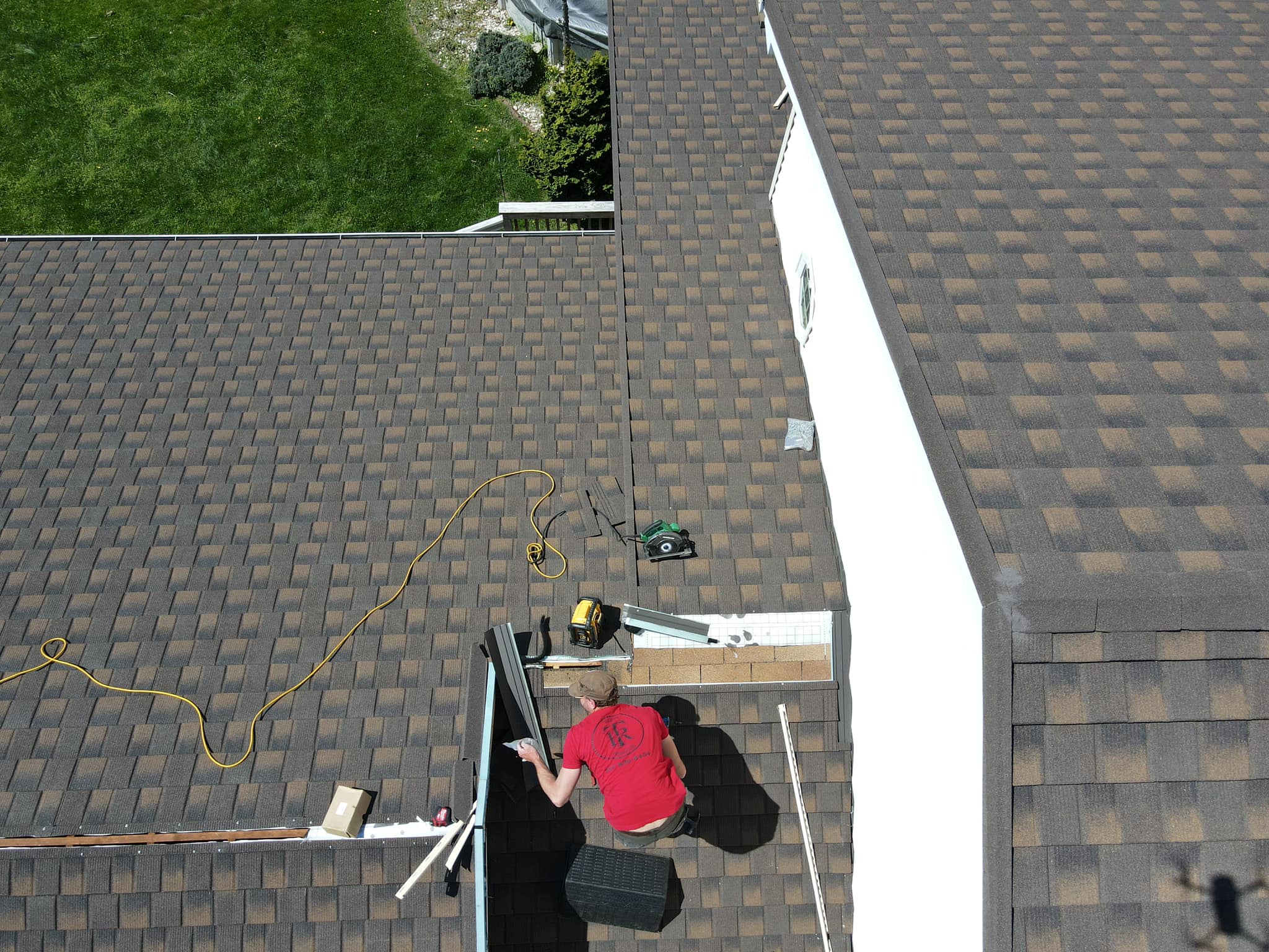 Man on roof finishing repairs on shingles